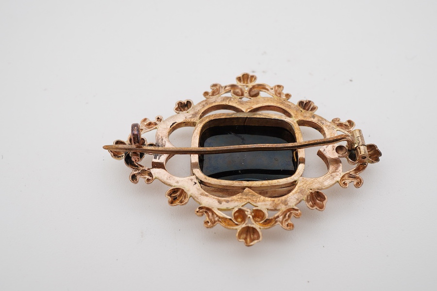 A yellow metal and glass intaglio set brooch, carved with figures, of quatrefoil shape, 43mm.